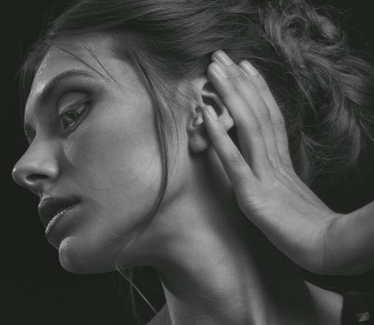 Black and white portrait of a woman with a thoughtful expression in a studio setting.