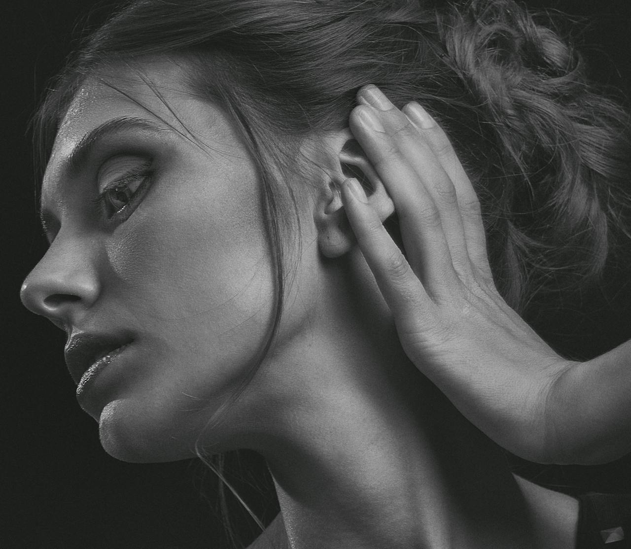 Black and white portrait of a woman with a thoughtful expression in a studio setting.